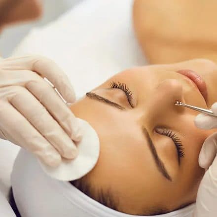 Profissional realizando extração com espátula durante limpeza de pele