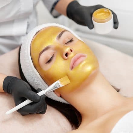 Aplicação de máscara facial dourada hidratante com pincel