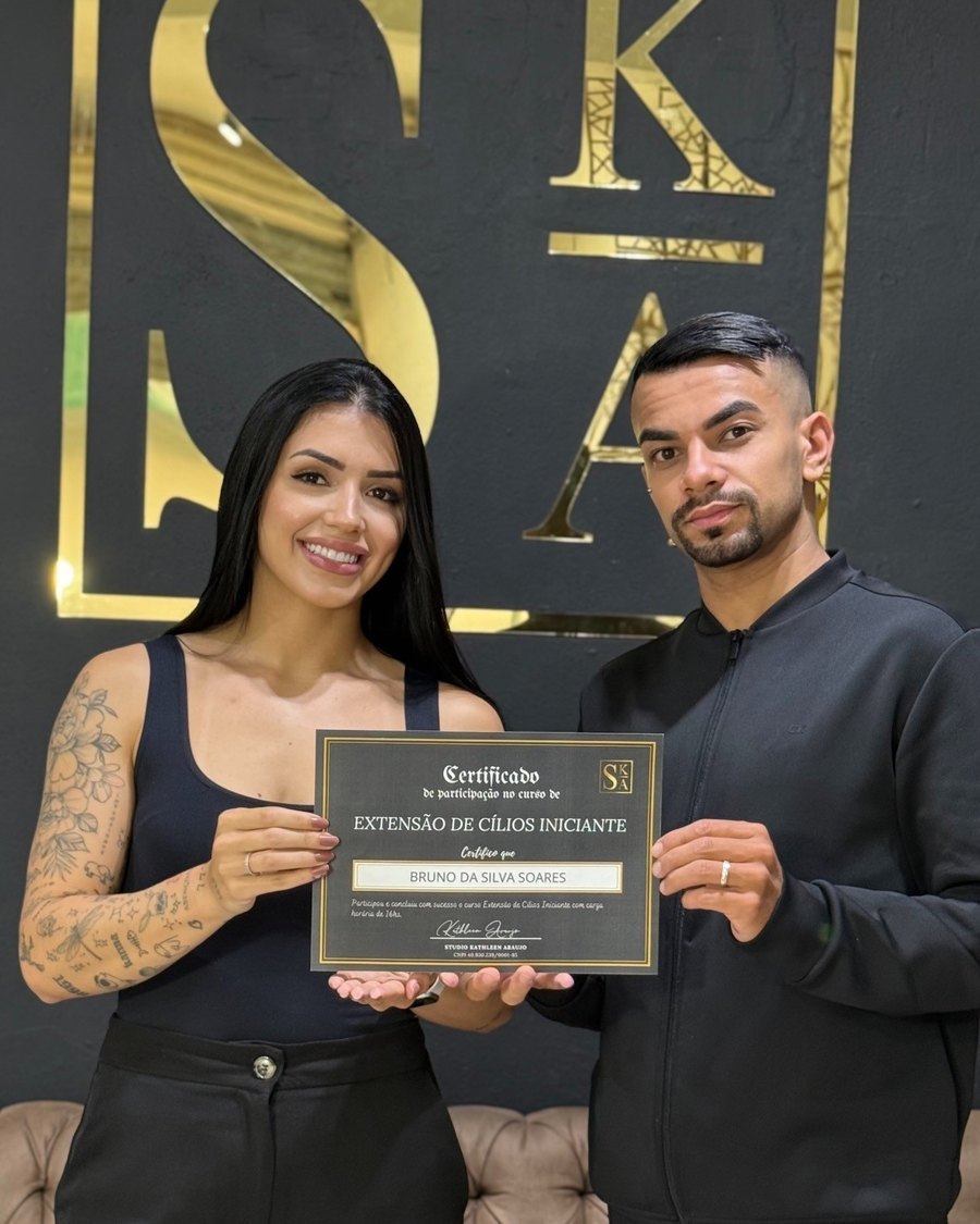 Aluno e aluna com o certificado do curso no studio