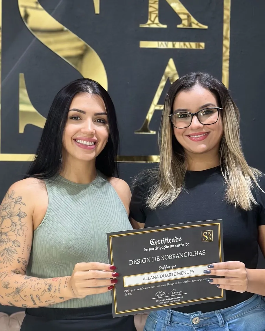 Aluna formada segurando o certificado no Studio Kathleen Araújo